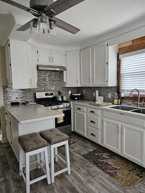 Enjoy cooking in this kitchen with a central island, stainless steel stove, and oven.