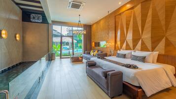 A modern hotel room with a large bed, a sofa, and a glass-enclosed bathroom.