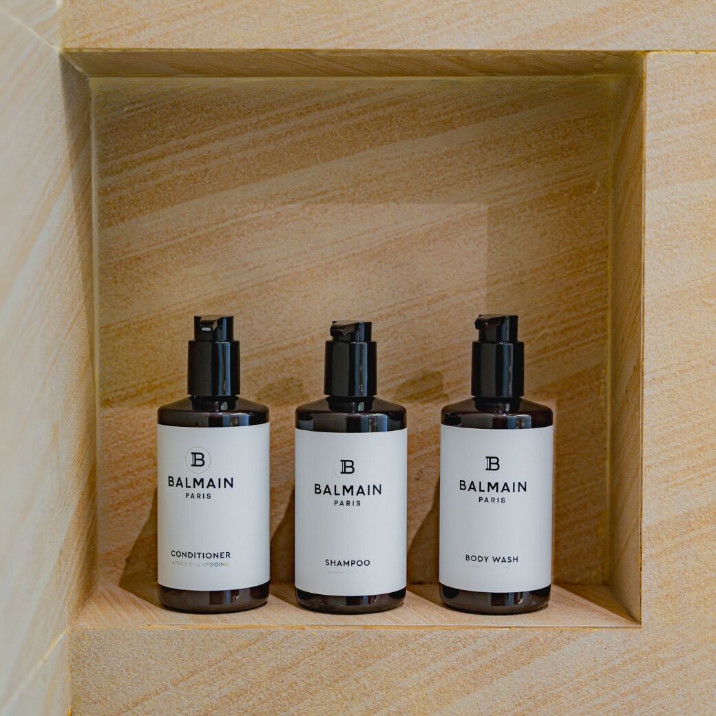 Trois produits Balmain Paris présentés dans une boîte en bois.