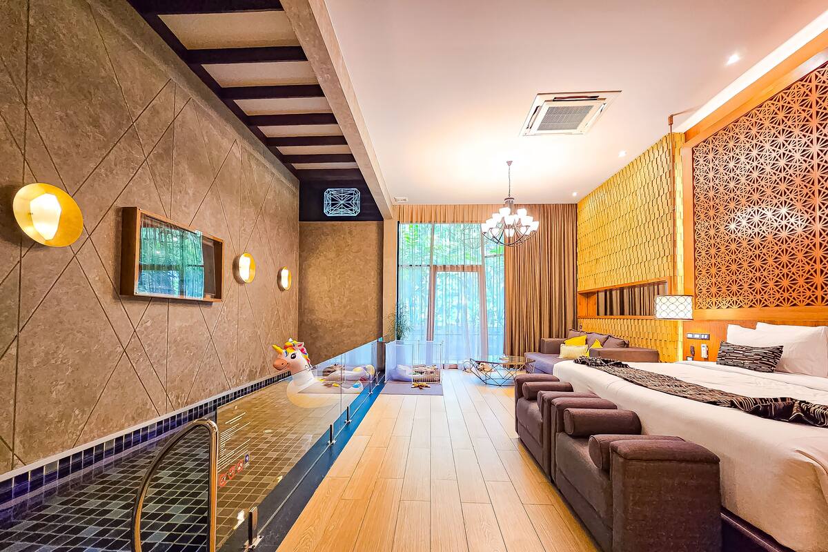 Een moderne hotelkamer met een groot bed, een zithoek en uitzicht op de omgeving.