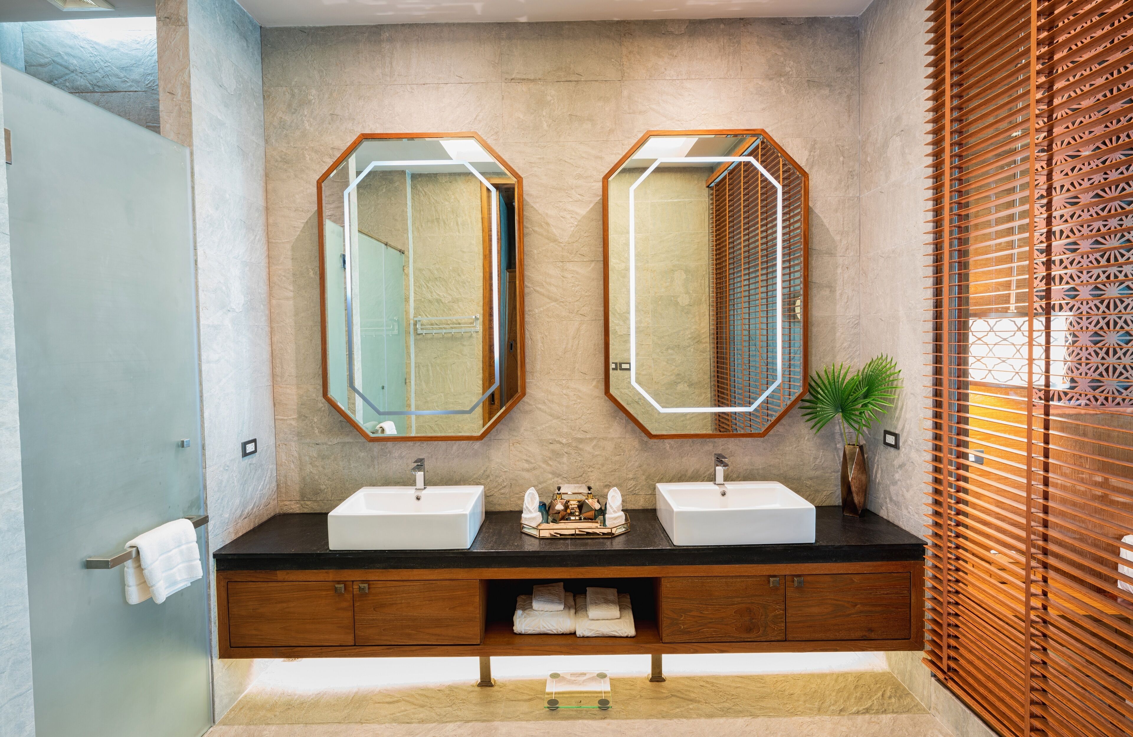 Une salle de bain moderne avec deux lavabos, un grand miroir et un meuble-lavabo en bois.