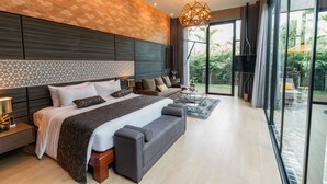 Une chambre moderne avec un grand lit, un canapé et une vue sur l’extérieur.