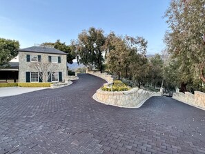 Un camino de adoquines conduce a una casa de piedra con garaje.