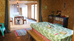 Een knus ingerichte kamer met een bed, bureau en stoel. Er ligt een houten vloer en er is een raam.