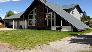 A stone house with a sloped roof and a large garage. - Mountain View Cabin 22 Miles From Yellowstone (Island Park)