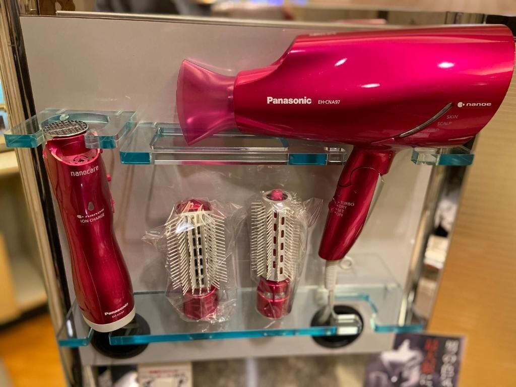 A Panasonic hair dryer and two hairbrushes on display.