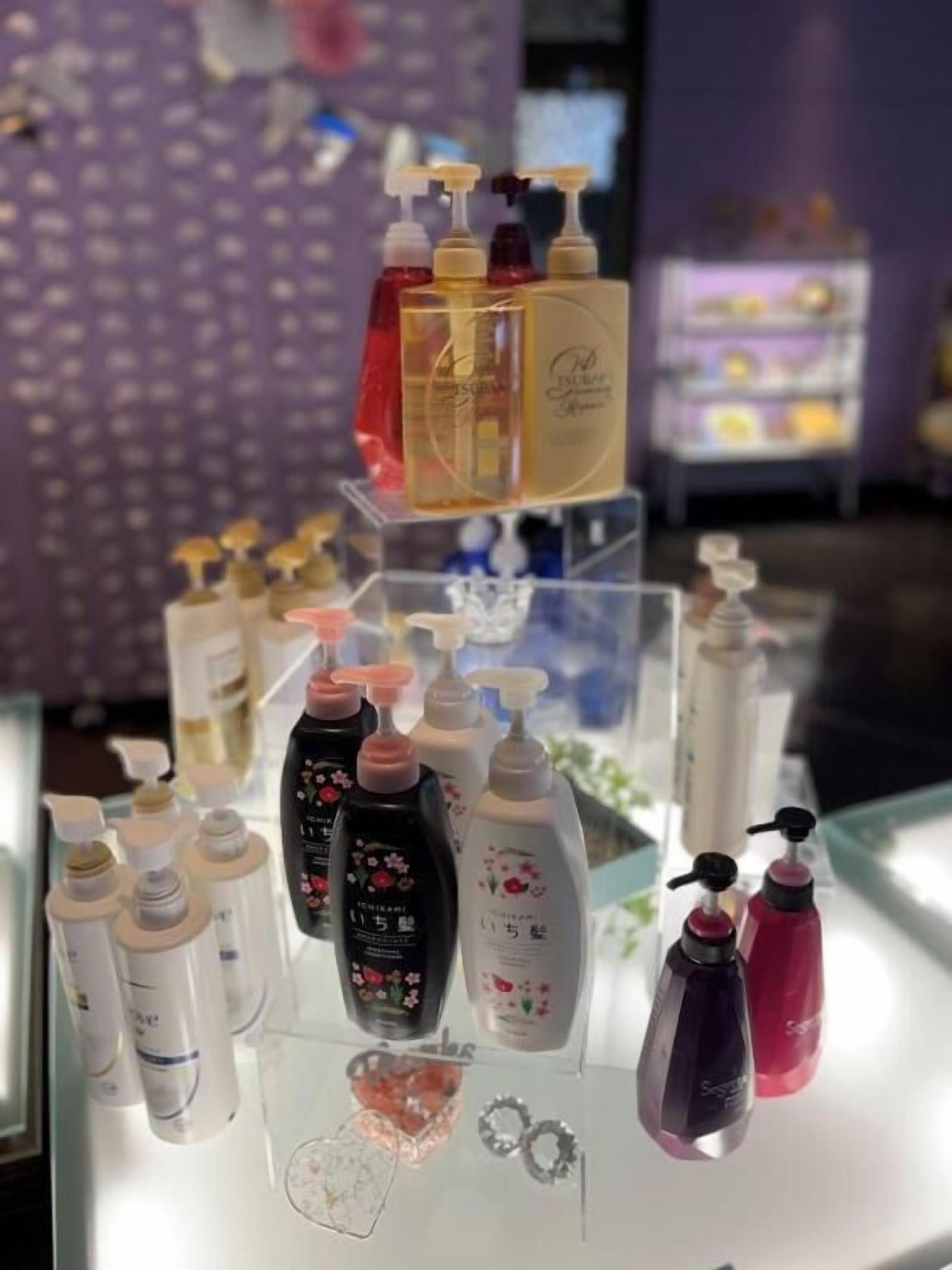 Una exhibición de diversos productos de cuidado personal sobre una repisa de vidrio.