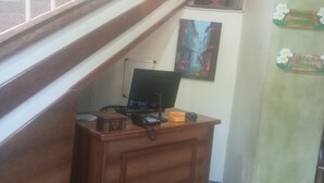 Een bureau met een computer, telefoon en een klein decoratief object.