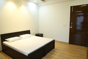 Un dormitorio con cama, mesita de noche y armario.