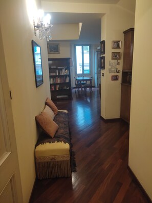 Un salon comprenant un canapé, une bibliothèque et un coin repas avec une table et des chaises.