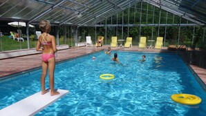 A swimming pool with a diving board, lounge chairs, and a covered area. - Residence Klementhof #1 (Naz Sciaves)