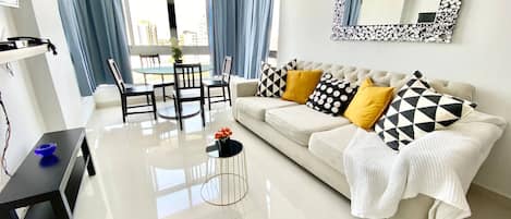 Una sala moderna con sofá, mesa de centro y comedor.