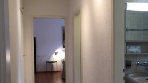 Käytävällä on penkki, pesuallas ja peili, ja se johtaa kylpyhuoneeseen.