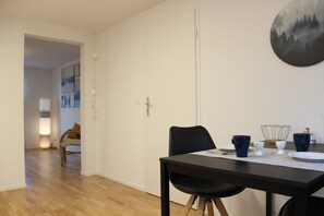 Un espace repas comprenant une table, des chaises et un tableau accroché au mur.