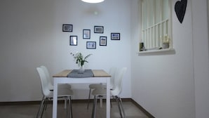 A dining area with a table, chairs, a hanging light fixture, and a heart-shaped decoration on the wall. - Casa Schilling- 2,5 Rooms With Balcony Near Hospital, University (St. Gallen)