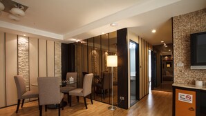 A modern hotel room with a dining area, a sofa, a lamp, and a sign prohibiting smoking. - 2A - 2 Bedroom Downtown Apartment With Shared Pool (Bangkok)