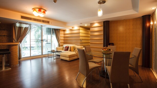 A modern living room with a glass dining table, a sofa, and a coffee table. - 2B - 2 Bedrooms and 2 Bathrooms Located Downtown Apartment With Shared Pool (Bangkok)