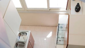 Eine Küche mit Spüle, Schränken und einem Fenster über der Spüle.
