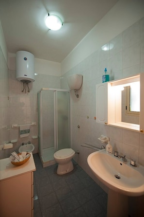 A bathroom with a toilet, sink, shower, and a toilet paper holder. - "At Casa Di Rafè in Gallipoli" (Gallipoli)