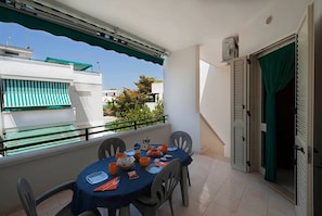 A balcony with a table set for dining, chairs, and a view of neighboring buildings. - "At Casa Di Rafè in Gallipoli" (Gallipoli)