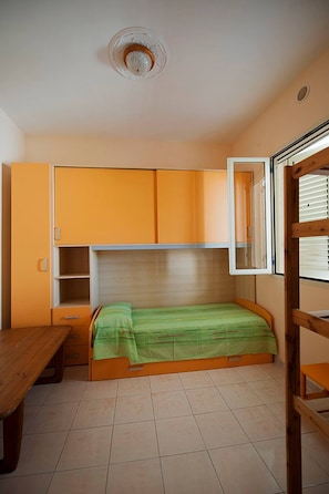 A small room with a bed, a wooden table, and a cabinet. - "At Casa Di Rafè in Gallipoli" (Gallipoli)