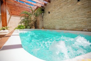 A hot tub with a wooden pergola and a brick wall. - Room-cozy 1bd With Common Jacuzzi (Sosúa)