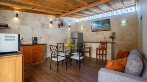Un espace de vie compact comprenant un coin repas, une kitchenette et un canapé.