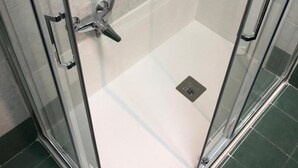 A glass-enclosed shower with a handheld showerhead, a wall-mounted faucet, and a small drain in the floor. - Room-come and Visit Naples !! We Look fo (Naples)