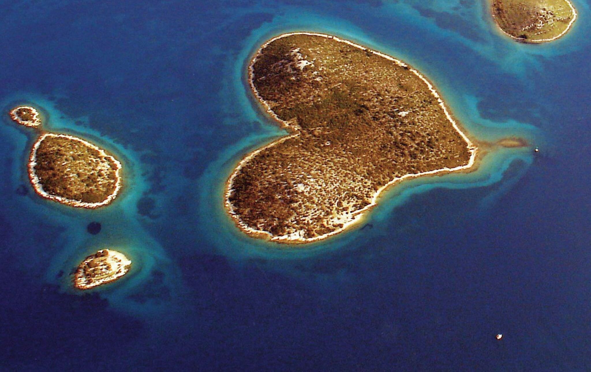 A satellite view of a group of islands with clear blue waters and sandy beaches.