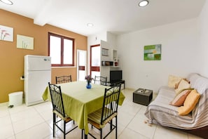 Um espaço compacto com área de refeições, cozinha compacta e sofá.