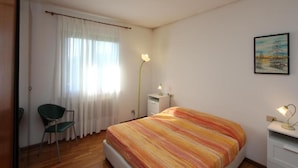 A bedroom with a bed, a chair, a desk, and a painting on the wall. - Charming Apartment in Cividale del Friuli (Cividale del Friuli)