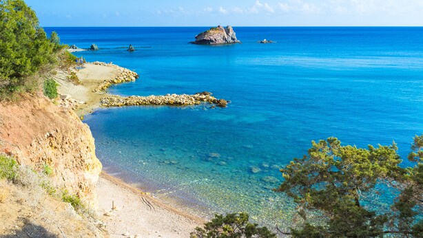 A coastal landscape with clear blue waters, rocky shorelines, and sparse vegetation. - Sanders White Mountains - Inviting Villa With Pool (Tremithousa)