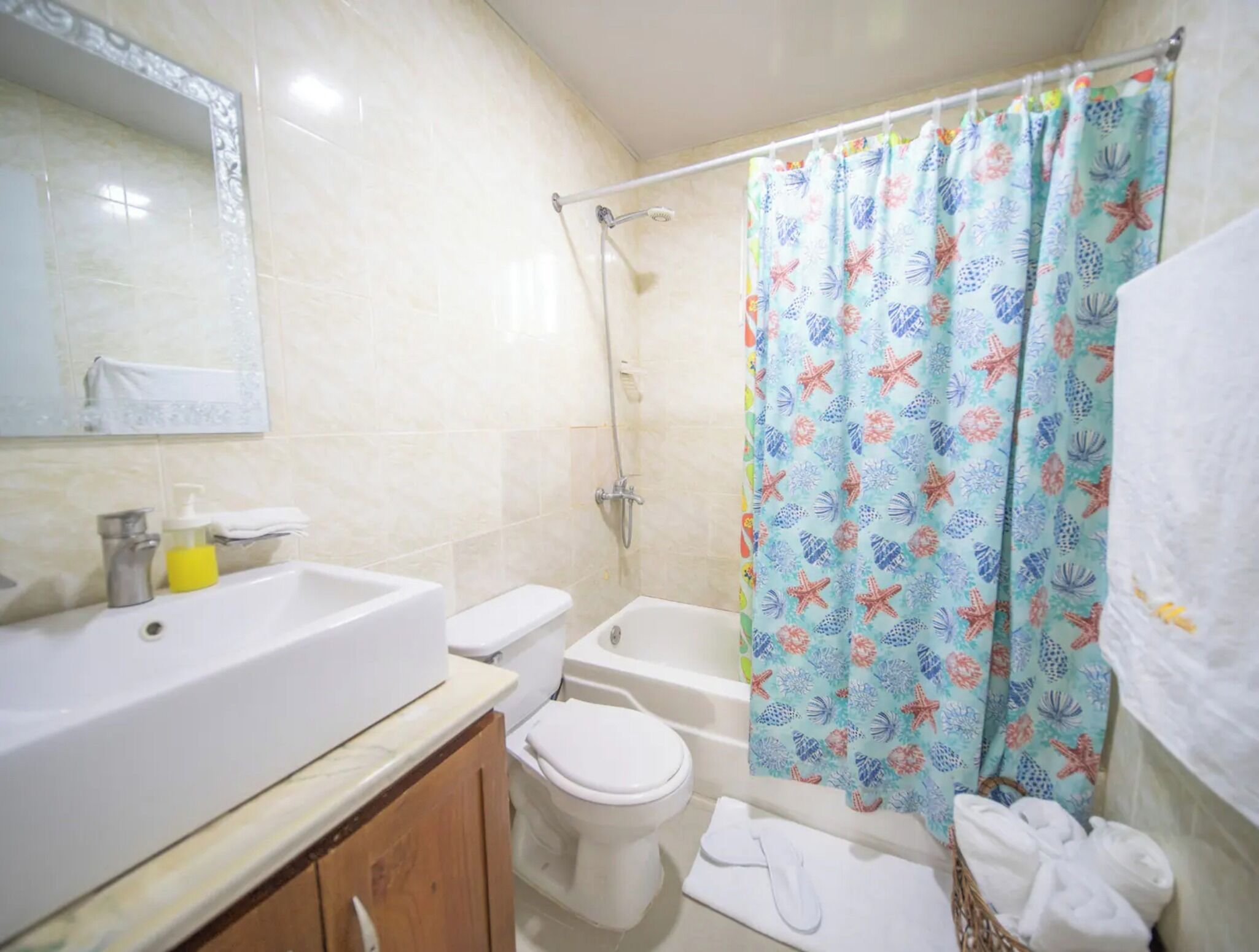 Een badkamer met een wastafel, toilet, bad en douchegordijn.