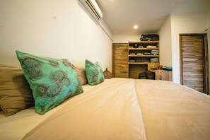 A bedroom with a bed, pillows, a wardrobe, and a suitcase. - Ti Baz Beach House With Mountain View (Tamarin)