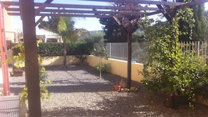 A covered patio area with gravel flooring, potted plants, and a wooden pergola structure. - 3 Bed Apt loc Marinella Pizzo Vv 89812 Calabria, Southern Italy (Pizzo)