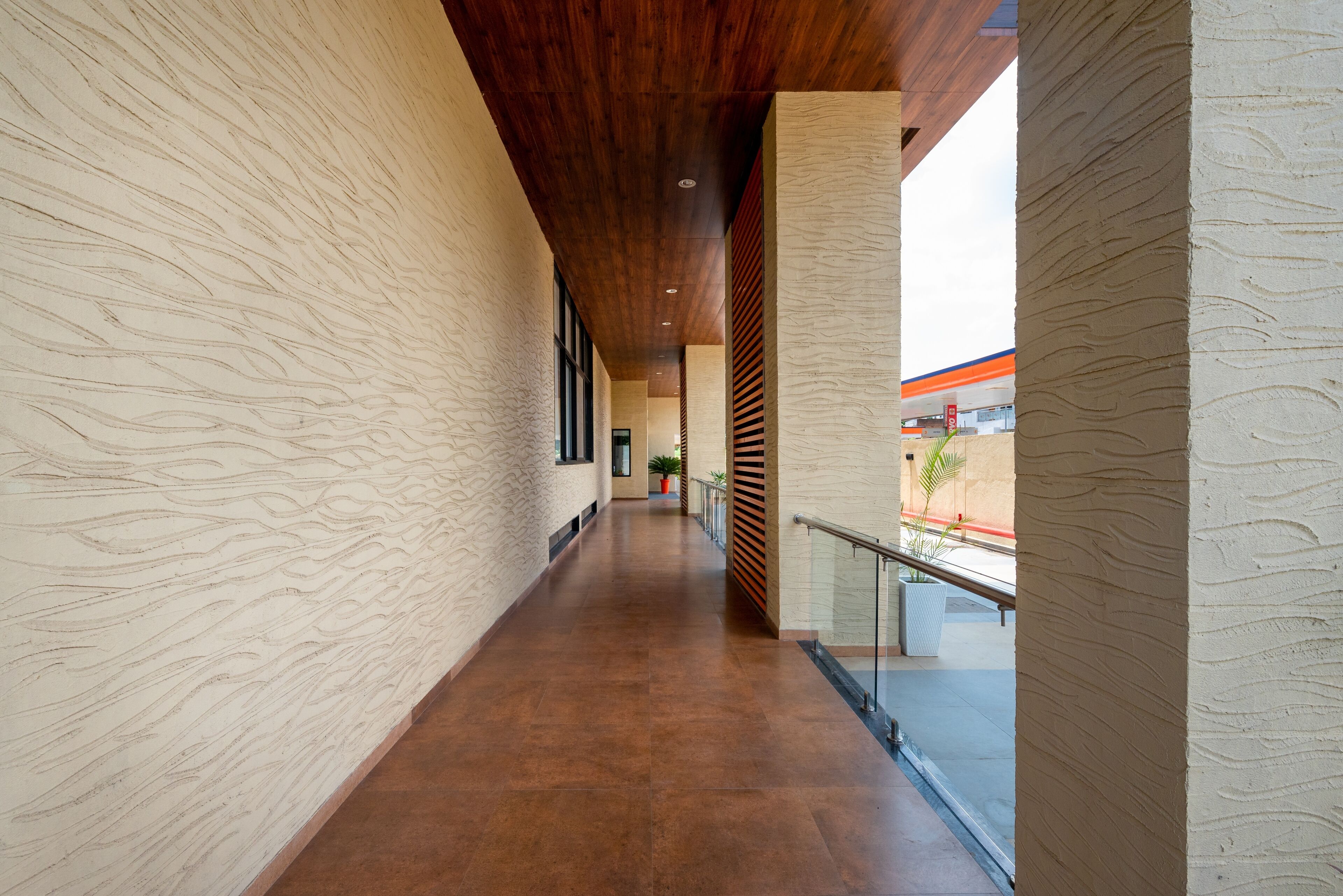 A long, narrow hallway with textured walls and a wooden ceiling.