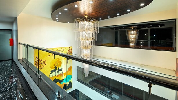 Ein modernes Interieur mit Glastrennwand, einem Chandelier und einem Wandgemälde.
