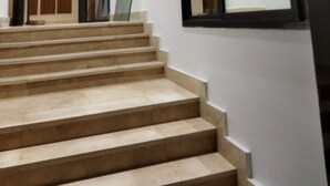 A staircase leading to a room with a large mirror and a door. - Apartment (Bouznika)