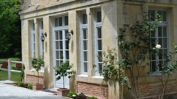 A stone building with large windows and a brick base. - Orangerie. (Saint-Justin)
