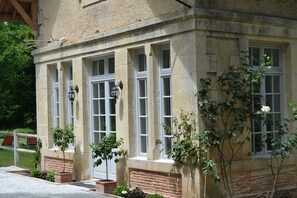 Un bâtiment en pierre doté de grandes fenêtres et d’un soubassement en briques.