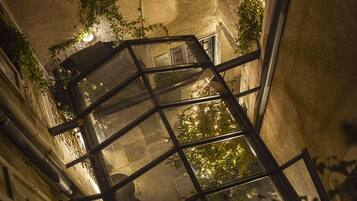 Vista nocturna del interior de un edificio con varias ventanas y una escalera.