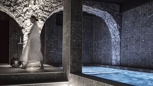 A stone-walled spa area with a hot tub and steps leading up to it. - Petit Hôtel Confidentiel (Chambery)
