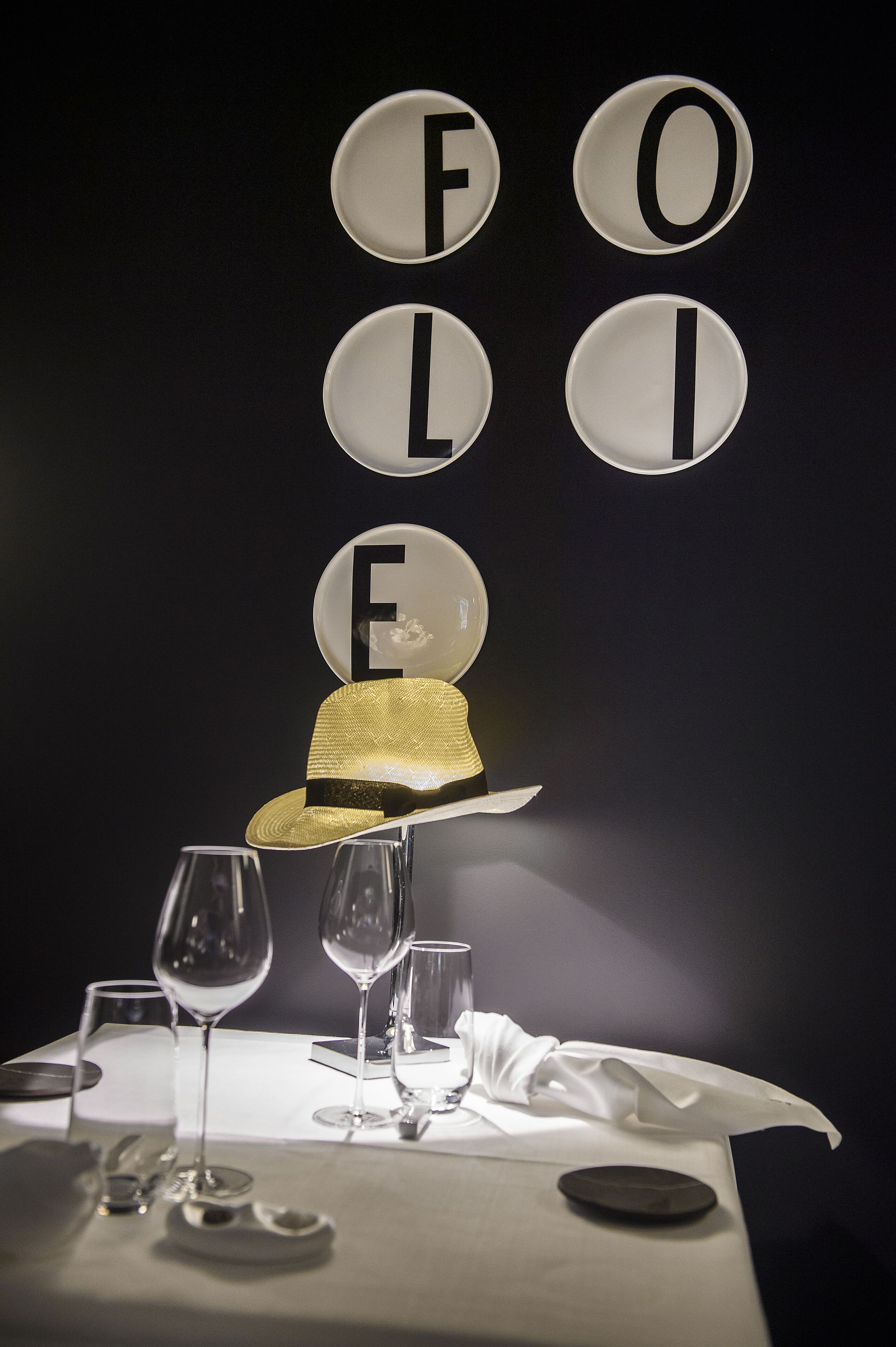 A table set for a meal with a hat and glasses on it.
