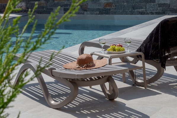 Piscine extérieure en saison, chaises longues
