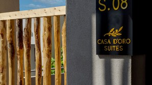 A sign for "Casa D'oro Suites" with the number "S.08" on a building facade.