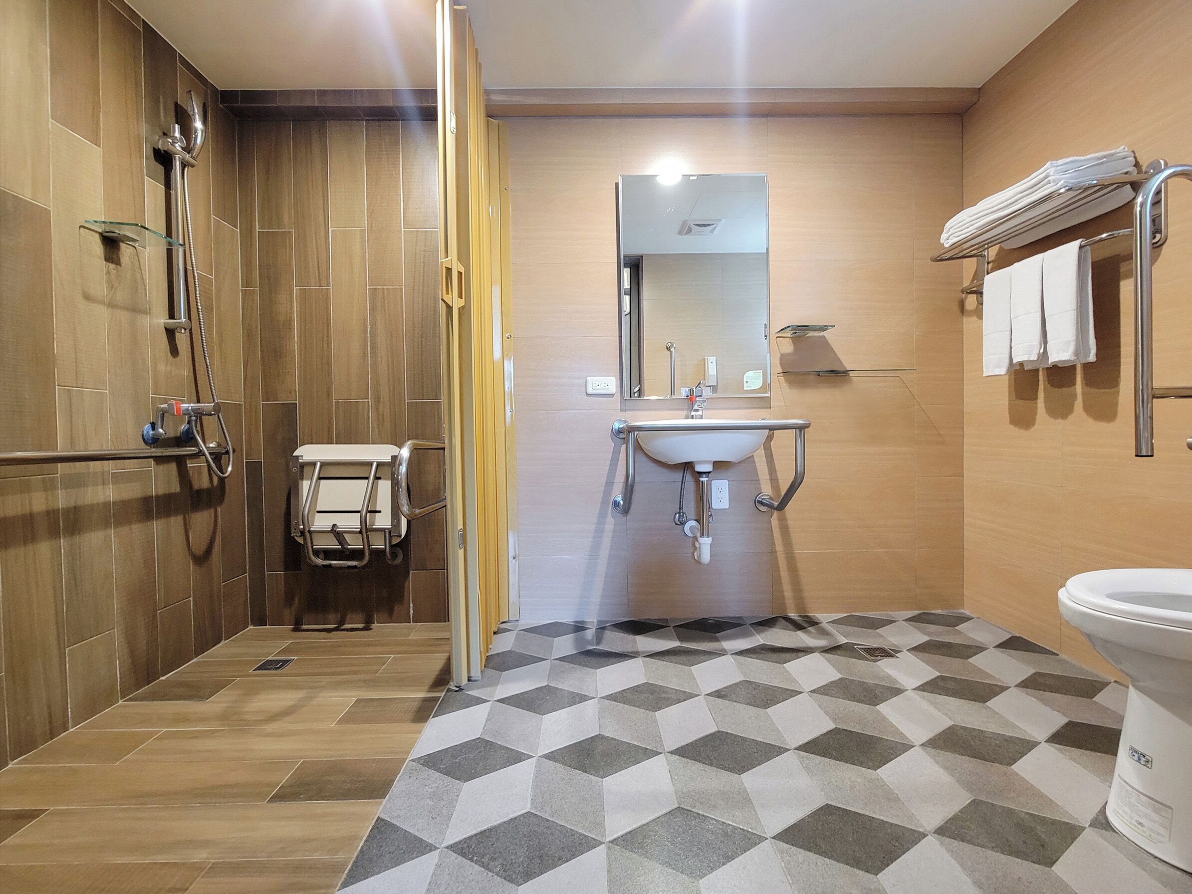 A modern bathroom with a shower, sink, and toilet.