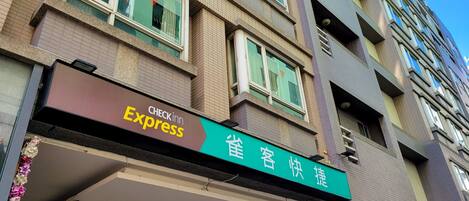 A hotel with a Check-in Express sign and a green sign with Chinese characters.