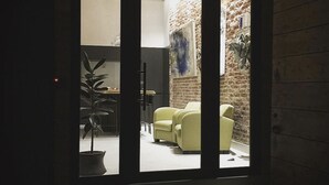 A room with a large window, a yellow sofa, and a potted plant. - At the Well of Light Suites Sandolo: double/single bedroom w/private bath. (Venezia)