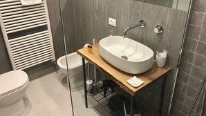 A modern bathroom with a freestanding sink, a toilet, and a bidet. - At the Well of Light Suites Sandolo: double/single bedroom w/private bath. (Venezia)