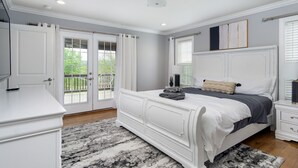 A bedroom with a large bed, a dresser, and a window with blinds. - Mountain Views, Hot Tub, Game Room | 20 min to Asheville! One Mile to Mars Hill University! (Mars Hill)
